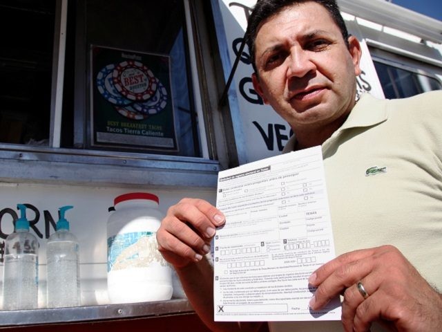 Carlos Zamora shows a voter registration card from a pile placed on the counter of the Tierra Caliente taco truck on Thursday, Sept. 29, 2016, in Houston. Zamora is with Mi Familia Vota, a Latino activist group that seeks to register more voters in the Latino community. Mi Familia Vota partnered with a local design firm to make eight of the city's taco trucks into mobile voter registration booths after a surrogate of Republican presidential candidate Donald Trump recently suggested that unless the United States fortifies its borders and tightens immigration limits, 