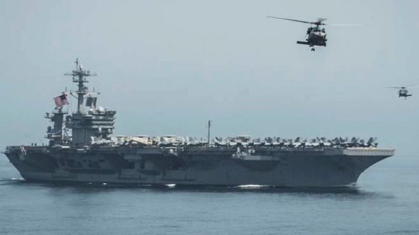 In this April 13, 2015 photo released by U.S. Navy Media Content Services, helicopters fly from the aircraft carrier USS Theodore Roosevelt during a vertical replenishment with the aircraft carrier USS Carl Vinson in the Gulf of Oman. The U.S. Navy has dispatched USS Theodore Roosevelt toward the waters off Yemen to join other American ships prepared to intercept any Iranian vessels carrying weapons to Houthi rebels, U.S. officials said on Monday. (Mass Communication Specialist 2nd Class Scott Fenaroli/ U.S. Navy Media Content Services via AP)