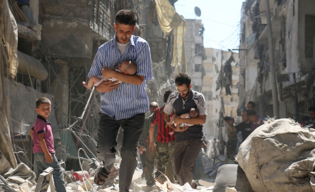 Syrian men carrying babies through Aleppo