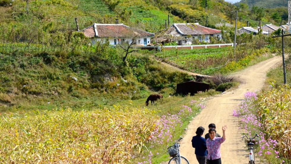 Villagers waving by the race path.