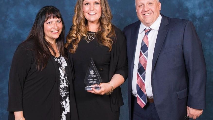 In this Tuesday, March 9, 2017 photo, provided by the Michigan Department of Corrections, Candice Dunn, center, stands with employees Heather Wayne and Brock Dietrich after receiving the state's parole/probation agent of the year award in East Lansing, Mich. Dunn was one of five people killed in a car crash Tuesday, May 9, in Livingston County. (Michigan Department of Corrections via AP)