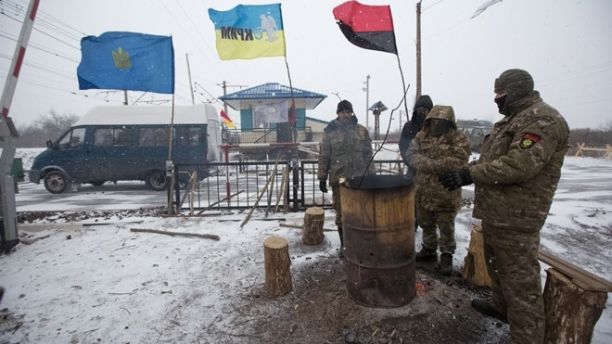Activists warm themselves at a fire in a camp at Kryvyi Torets station as they take part in a rail blockade that has halted coal supplies in the village of Shcherbivka in Donetsk region, Ukraine, February 14, 2017. Picture taken February 14, 2017.  REUTERS/Konstantin Chernichkin - RTS10M68