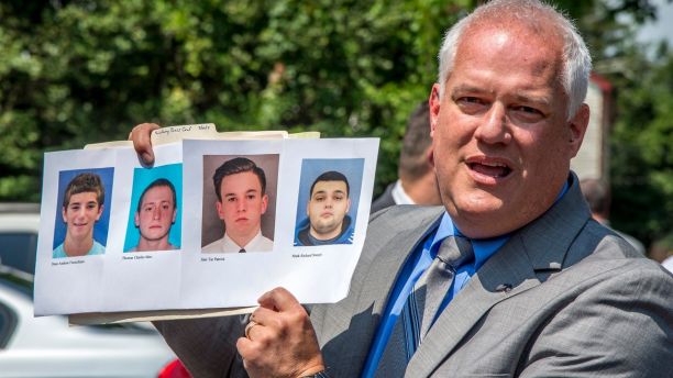 Bucks County District Attorney Matthew Weintraub holds up photos of four men who are missing during a news conference in Solebury Township, Pa., Monday, July 10, 2017. The four men, who went missing last week, are Dean Finocchiaro, from left, Tom Meo, Jimi Tar Patrick and Mark Sturgis. (Clem Murray/The Philadelphia Inquirer via AP)