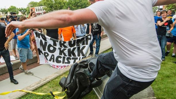 A protester kicks the toppled statue of a Confederate soldier after it was pulled down in Durham, N.C. Monday, Aug. 14, 2017. Activists on Monday evening used a rope to pull down the monument outside a Durham courthouse. The Durham protest was in response to a white nationalist rally held in Charlottesville, Va., over the weekend. (Casey Toth/The Herald-Sun via AP)
