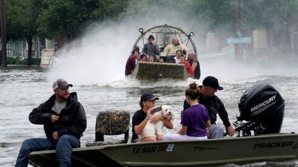 People are rescued from flood waters from Hurricane Harvey on an air boat in Dickinson, Texas August 27, 2017. REUTERS/Rick Wilking - RTX3DKR1