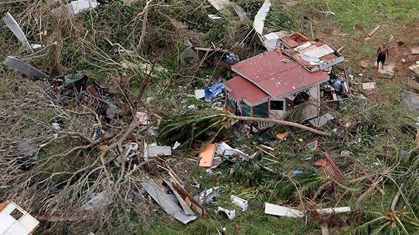 A man stands outside a destroyed home in this aerial photo from a Marine Corps MV-22 Osprey surveying the aftermath from Hurricane Maria in St. Croix, U.S. Virgin Islands September 21, 2017.  REUTERS/Jonathan Drake - RC1BCD434FE0