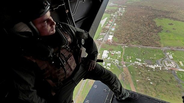 Marine air crewman Corporal Jordan Slay looks out over the destruction wrought by Hurricane Maria from the rear bay door os his MV-22 Osprey as it flies over St. Croix, U.S. Virgin Islands September 21, 2017.  REUTERS/Jonathan Drake - RC1B68416540