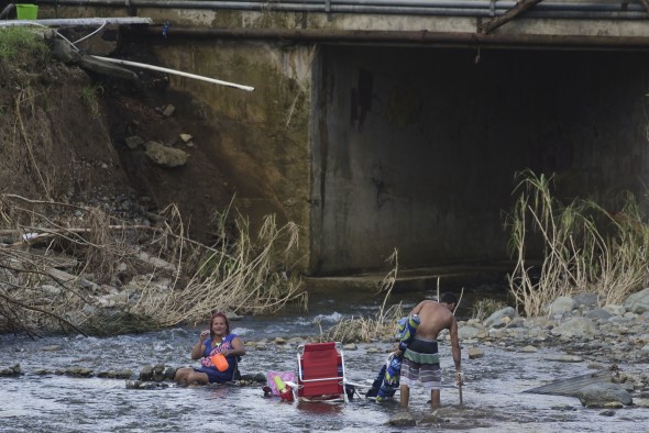 Couple bathes in Gurabo River -- PR Maria aftermath (AP)