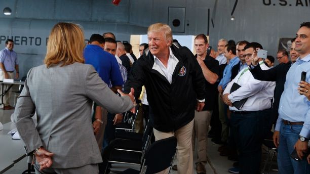 President Donald Trump shakes hands with San Juan Mayor Carmen Yulin Cruz during a briefing on hurricane recovery efforts with first responders at Luis Muniz Air National Guard Base, Tuesday, Oct. 3, 2017, in San Juan, Puerto Rico. (AP Photo/Evan Vucci)