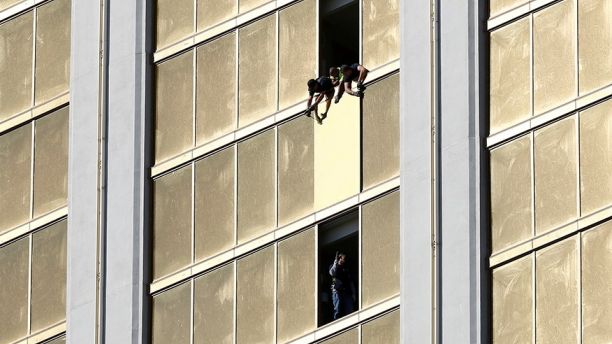 Workers board up a broken window at the Mandalay Bay hotel, where shooter Stephen Paddock conducted his mass shooting along the Las Vegas Strip, in Las Vegas, Nevada, U.S., October 6, 2017. REUTERS/Chris Wattie - RC17424B7F40