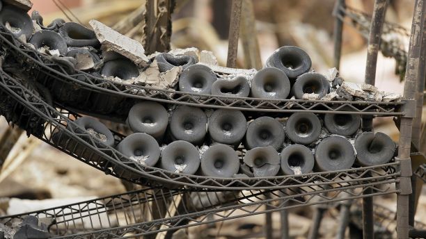 A rack of burned bottles of wine are seen at the Signorello Estate winery Tuesday, Oct. 10, 2017, in Napa, Calif. Worried California vintners surveyed the damage to their vineyards and wineries Tuesday after wildfires swept through several counties whose famous names have become synonymous with fine food and drink. (AP Photo/Eric Risberg)