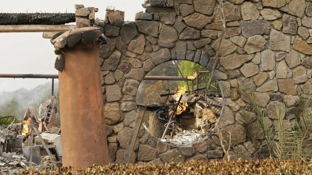 Flames continue to smolder at the Signorello Estate winery Tuesday, Oct. 10, 2017, in Napa, Calif. Worried California vintners surveyed the damage to their vineyards and wineries Tuesday after wildfires swept through several counties whose famous names have become synonymous with fine food and drink. (AP Photo/Eric Risberg)