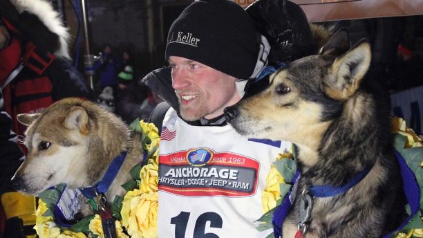 FILE - In this March 15, 2016, file photo, Dallas Seavey poses with his lead dogs Reef, left, and Tide after finishing the Iditarod Trail Sled Dog Race in Nome, Alaska. Seavey won his third straight Iditarod, for his fourth overall title in the last five years. Four-time Iditarod champion Dallas Seavey denies he administered banned drugs to his dogs in this year's race, and has withdrawn from the 2018 race in protest. The Iditarod Trail Committee on Monday identified Seavey as the musher who had four dogs test positive for a banned opioid pain reliever after finishing the race last March in Nome. (AP Photo/Mark Thiessen, File)