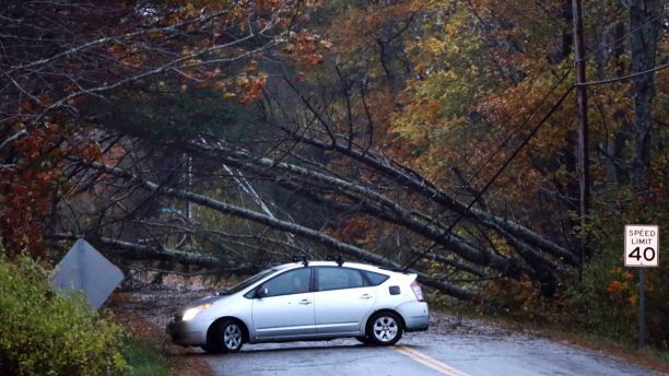 A motorist turns around after finding downed trees blocking Flying Point Road during a storm in Freeport, Maine, Monday, Oct. 30, 2017. A strong wind storm has caused widespread power outages. (AP Photo/Robert F. Bukaty)