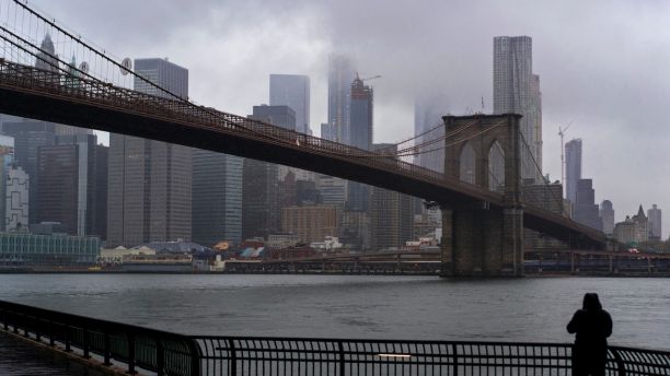 A person on the Brooklyn side of the East River faces the rain and clouds as they loom over lower Manhattan on the fifth anniversary of Superstorm Sandy, Sunday, Oct. 29, 2017, in New York. (AP Photo/Craig Ruttle)