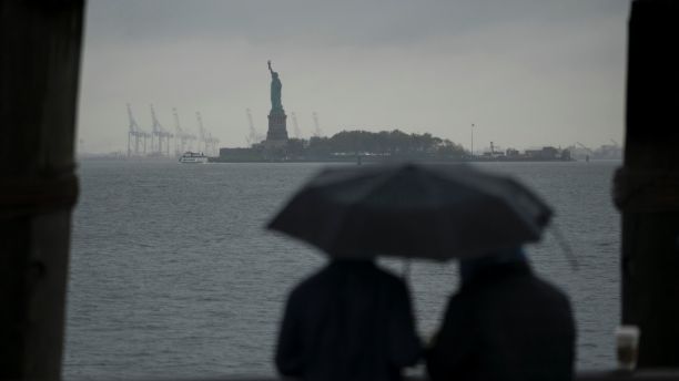 Rain and clouds loom over the Upper Bay and The Statue of Liberty as people visit Battery Park in Manhattan on the fifth anniversary of Superstorm Sandy, Sunday, Oct. 29, 2017, in in New York. (AP Photo/Craig Ruttle)