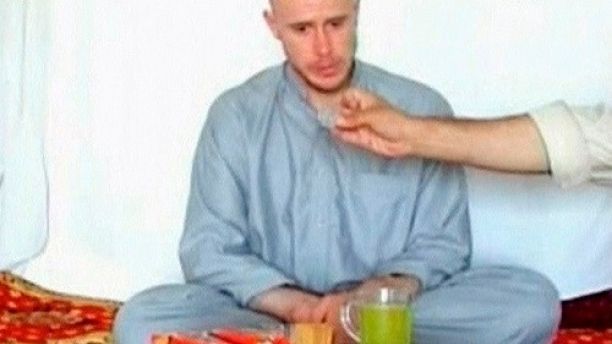 U.S. Army Private Bowe Bergdahl watches as one of his captors displays his identity tag to the camera at an unknown location in Afghanistan, July 19, 2009. The U.S. military denounced on Sunday the release of the video showing a soldier captured in Afghanistan, describing the images as Taliban propaganda that violated international law.  REUTERS/via Reuters TV  (AFGHANISTAN MILITARY CONFLICT) - GM1E57K09PB01