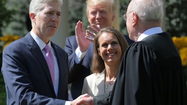 Judge Neil Gorsuch shakes hands with Supreme Court Associate Justice Anthony Kennedy after being sworn in as an Associate Justice of the Supreme Court, accompanied by Louise Gorsuch (C) and U.S. President Donald J. Trump in the Rose Garden of the White House in Washington, U.S., April 10, 2017. REUTERS/Carlos Barria - RTX34YQB