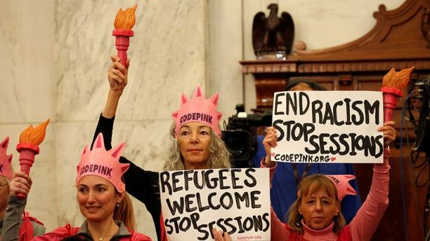 Protesters hold signs at the Senate Judiciary Committee confirmation hearing for U.S. Sen. Jeff Sessions (R-AL) to become U.S. attorney general on Capitol Hill in Washington, U.S. January 10, 2017. REUTERS/Kevin Lamarque - RC1F239772C0