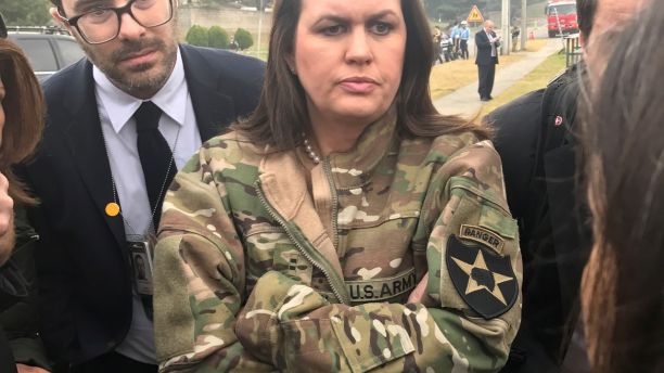 White House Press Secretary Sarah Huckabee Sanders, wearing a borrowed U.S. Army jacket to keep warm, updates reporters on President Donald Trump's failed attempt due to weather to visit Observation Post Ouellette along the Demilitarized Zone (DMZ) in the truce village of Panmunjom dividing North Korea and South Korea outside Seoul, South Korea, November 8, 2017. REUTERS/Steve Holland - RC1DE6D623A0