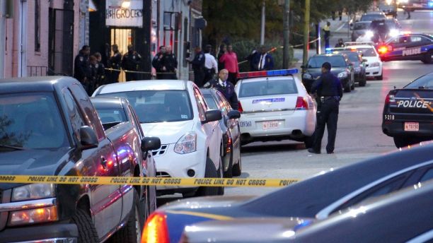 Police officers respond to Bennett Place and N. Fremont Avenue after a call went out that an officer is shot Wednesday, Nov. 15, 2017, in Baltimore, M.D. (Kevin Richardson/The Baltimore Sun via AP)