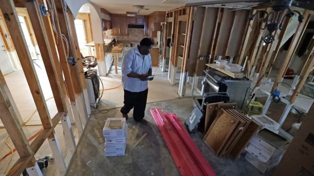 In this Nov. 17, 2017 photo, George Dorsey walks through his hurricane-damaged home in Houston. He usually hosts a large Thanksgiving dinner for family but is making other arrangements this year as he continues to recover from Hurricane Harvey. (AP Photo/David J. Phillip)