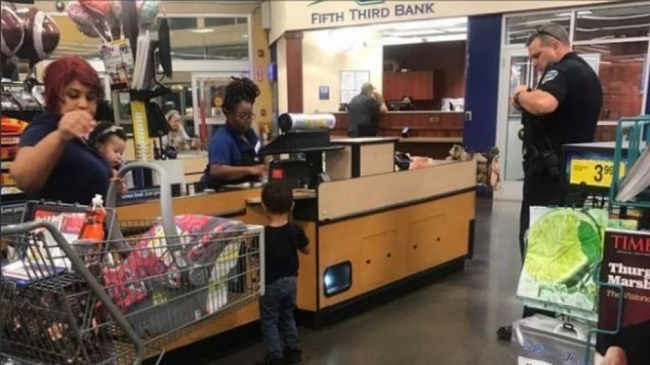 Kennesaw police officer Matt Wilson, right, helps a local mom.