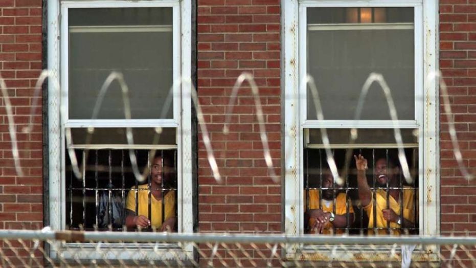 Inmates watch the arrival of temporary air conditioning units at the St. Louis Medium Security Institution.