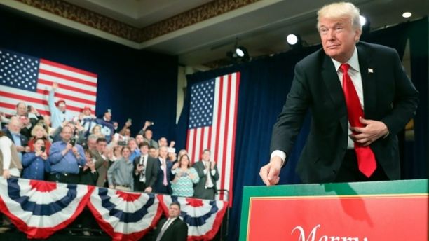 President Donald Trump points to sign that reads Merry Christmas as he arrives to speak about tax reform at the St. Charles Convention Center, Wednesday, Nov. 29, 2017, in St. Charles, Mo. (AP Photo/Andrew Harnik)
