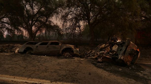 The burned remains of crashed cars are seen at night on a country road as strong winds push the Thomas Fire across thousands of acres near Santa Paula, California, U.S., December 5, 2017.      REUTERS/David McNew - RC130B5E1270