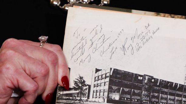 Beverly Young Nelson the latest accuser of Alabama Republican Roy Moore, shows her high school yearbook signed by Moore, at a news conference, in New York, Monday, Nov. 13, 2017. Nelson says Moore assaulted her when she was 16 and he offered her a ride home from a restaurant where she worked. Anticipating Nelson's allegations at the news conference, Moore's campaign ridiculed her attorney, Gloria Allred, beforehand as 