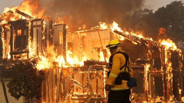 A firefighter monitors a house burning in Santa Rosa, Calif., Monday, Oct. 9, 2017. Wildfires whipped by powerful winds swept through Northern California sending residents on a headlong flight to safety through smoke and flames as homes burned. (AP Photo/Jeff Chiu)