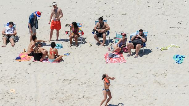 In this Sunday, July 2, 2017, photo, New Jersey Gov. Chris Christie, right, uses the beach with his family and friends at the governor's summer house at Island Beach State Park in New Jersey. Christie is defending his use of the beach, closed to the public during New Jersey's government shutdown, saying he had previously announced his vacation plans and the media had simply 