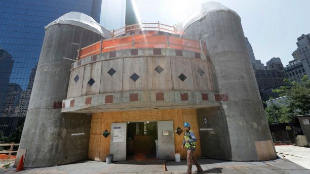 FILE- In this Aug. 10, 2017 file photo, a construction worker walks in front of the St. Nicholas National Shrine in New York. Work on the Greek Orthodox church destroyed in the Sept. 11 attacks next to the World Trade Center memorial plaza has been temporarily suspended by the construction company.  It comes amid financial difficulties and questions over how funds have been managed. (AP Photo/Mark Lennihan, File)