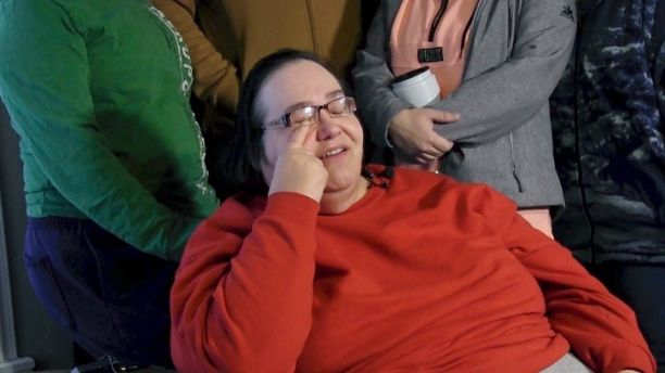 Lisa Finch, surrounded by family members reacts to the killing of her son Andrew Finch after he was shot Thursday evening, Dec. 28, 2017, by police, in Wichita, Kan. Authorities are investigating whether the deadly police shooting stemmed from someone making up a false report to get a SWAT team to descend upon a home in a prank common in the online gaming industry known as 