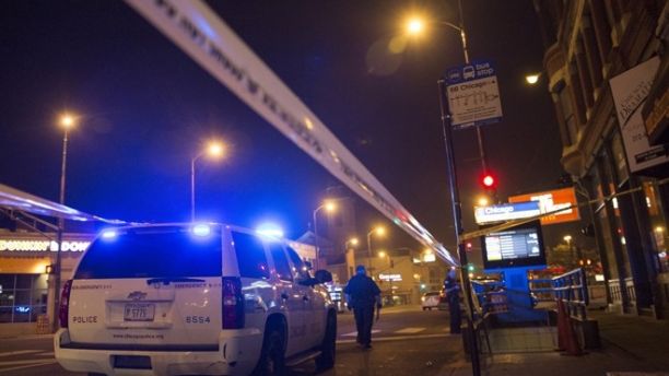 Chicago police officer investigate a crime scene of a gunshot victim in Chicago, Illinois, United States, July 5, 2015. Extra police patrols and long shifts were not enough to prevent nine deaths and about 50 injuries from gun violence in Chicago over the Fourth of July weekend, when homicides jump almost every year. Chicago, with 2.7 million people, is the most violent large city in the United States, with poverty, segregation, dozens of small street gangs, and a pervasive gun culture all contributing to the problem. Picture taken July 5, 2015. REUTERS/Jim Young     - RTX1JA21