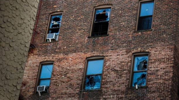 This Friday, Dec. 29, 2017, photo shows broken windows on the back of the building where more than 10 people died Thursday in a fire in the Bronx borough of New York. New York City's deadliest residential fire in decades was accidentally lit by a 3 ½-year-old boy playing with the burners on his mother's stove, officials said Friday. (AP Photo/Andres Kudacki)