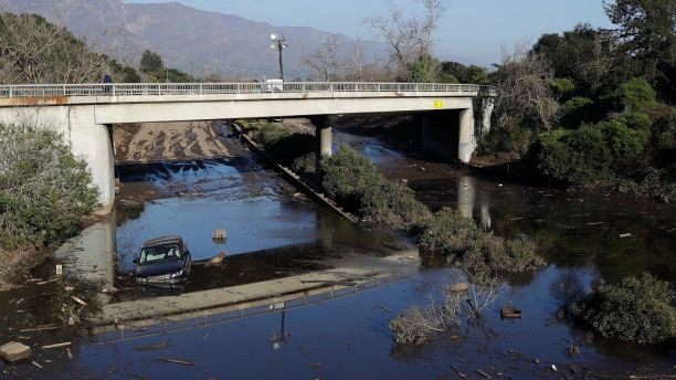 A car sits in flooded water on Highway 101 in Montecito, Calif., Thursday, Jan. 11, 2018. Rescue workers slogged through knee-deep ooze and used long poles to probe for bodies Thursday as the search dragged on for victims of Tuesday's storm after mudslides slammed this wealthy coastal town. (AP Photo/Marcio Jose Sanchez)