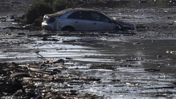 A car sits in flooded water in Montecito, Calif., Thursday, Jan. 11, 2018. Rescue workers slogged through knee-deep ooze and used long poles to probe for bodies Thursday as the search dragged on for victims of Tuesday's storm after mudslides slammed this wealthy coastal town. (AP Photo/Marcio Jose Sanchez)
