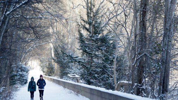 Brooke Meadows, left, and Alex Ondrus go for a walk in Radnor Lake State Park, Tuesday, Jan. 16, 2018, in Nashville, Tenn. A winter storm brought snow and cold temperatures to the area, causing the closing of schools and businesses. (AP Photo/Mark Humphrey)