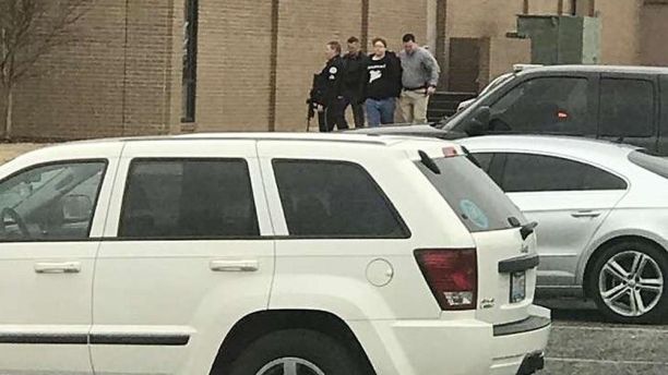 UPDATES TO REMOVE NUMBER OF PEOPLE INJURED - Police escort a person, second from right, out of the Marshall County High School after shooting there, Tuesday, Jan 23, 2018, in Benton, Ky.  Gov. Matt Bevin said two people were killed numerous others were injured in the shooting. (Dominico Caporali via AP)