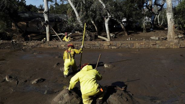 A Cal Fire search and rescue crew walks through mud near homes damaged by storms in Montecito, Calif., Friday, Jan. 12, 2018. The mudslide, touched off by heavy rain, took many homeowners by surprise early Tuesday, despite warnings issued days in advance that mudslides were possible because recent wildfires had stripped hillsides of vegetation that normally holds soil in place.
(AP Photo/Marcio Jose Sanchez)