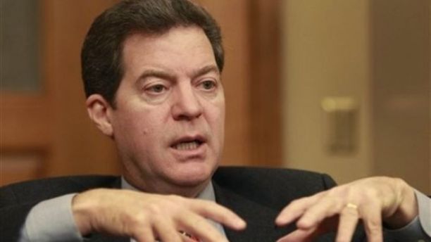 Dec. 21, 2010: Kansas Gov. Sam Brownback is shown before taking office talking with a reporter in Topeka.