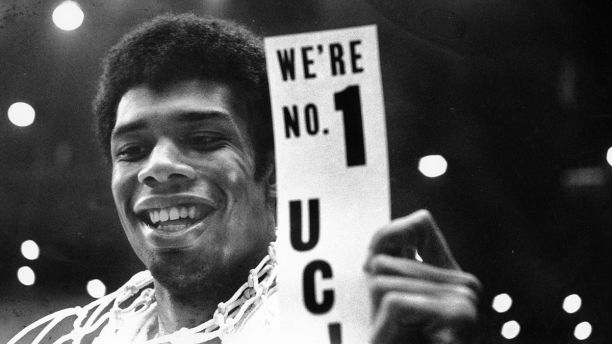 FILE - In this March 23, 1968, file photo, UCLA's Lew Alcindor, with the basket netting draped over his shoulders, holds a sign just after leading UCLA to the NCAA basketball championship in Los Angeles on March 23, 1968. Muhammad Aliââ¬â¢s actions influenced others. Alcindor boycotted the 1968 Summer Olympics. boycotted the 1968 Summer Olympics. After winning his first NBA championship in 1971, he took the Muslim name Kareem Abdul-Jabbar. (AP Photo/File)