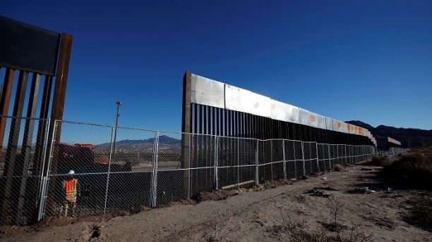 A worker stands next to a newly built section of the U.S.-Mexico border fence at Sunland Park, U.S. opposite the Mexican border city of Ciudad Juarez, Mexico January 25, 2017. Picture taken from the Mexico side of the U.S.-Mexico border. REUTERS/Jose Luis Gonzalez - RC1E79E73750