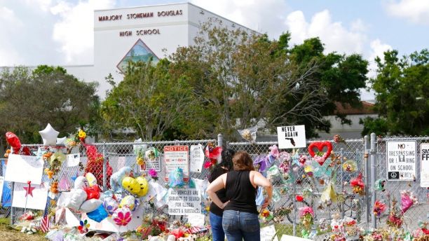 Mourners pay tribute at a memorial for the victims of the shooting at Marjory Stoneman Douglas High School on Sunday, Feb. 25, 2018, in Parkland, Fla. (David Santiago/Miami Herald via AP)