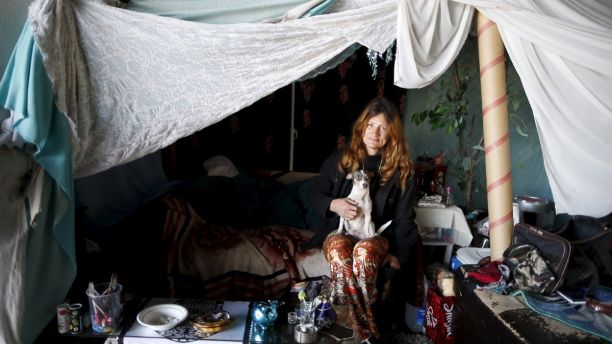 Karen Souza, 55, poses for a portrait with her dog Handsome by the tent in which she lives, under a freeway on a street in Los Angeles, California, United States, November 13, 2015. Souza has been homeless for a decade, and has known Kathleen Fox for 20 years. She originally became homeless after her spouse was arrested,