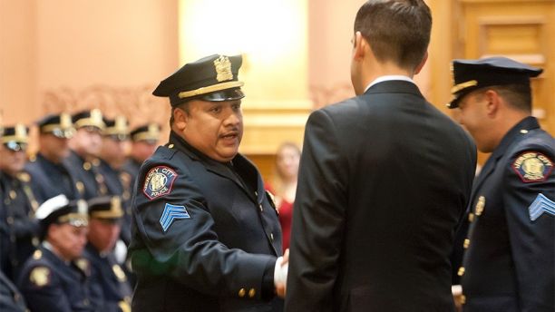 In this 2014 photo, Jersey City Police Sgt. Christopher Robateau, left, hands with Mayor Steve Fulop when he was promoted to lieutenant with the Jersey City Police Department in 2014. Robateau, 49, was killed on the New Jersey Turnpike, Friday morning, Jan. 5, 2018. As he exited his car to help a motorist on his way to work, Robateau was struck by a vehicle. (Reena Rose Sibayan/The Jersey Journal via AP)