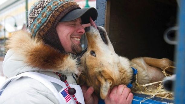 Rookie musher Matt Failor, of Willow, Alaska, gets friendly with Pantera, a female dog in his team, prior to the ceremonial start of the Iditarod Trail Sled Dog Race, Saturday, March 3, 2018, in Anchorage, Alaska. (AP Photo/Michael Dinneen)