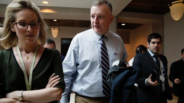 FILE - In this Jan. 16, 2018, file photo, Rep. Thomas Rooney, R-Fla., center, talks with reporters as he leaves a House Intelligence Committee meeting where the committee is interviewing former White House strategist Steve Bannon behind closed doors on Capitol Hill in Washington. Partisan sparring over the Russia investigation is causing chaos on the traditionally bipartisan House intelligence committee _ with the panel now planning to build a wall to separate Republican and Democratic staff who have long sat side by side. Rooney, said Feb. 8 that he thinks the committee is âpoisonâ right now, characterizing partisan tensions as a total breakdown on committee that could have national security concerns(AP Photo/Jacquelyn Martin, File)